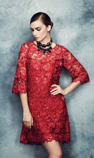 model wears red lace dress and black beaded necklace