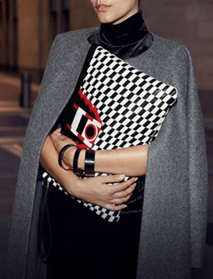 model holds black and white print clutch
