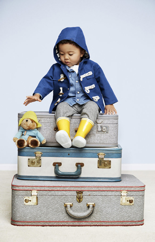 little boy on suitcase with Paddington Bear toy
